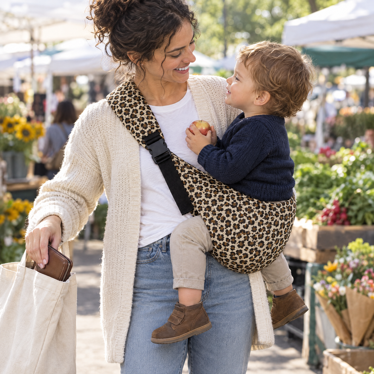 Mutter mit Kind in der HipSnug Babytrage auf dem Wochenmarkt