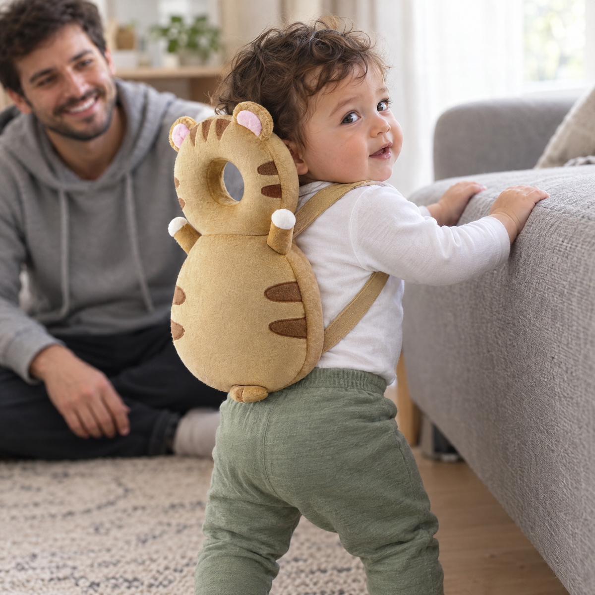 Kleinkind zieht sich am Sofa hoch mit dem SoftFall Kopfschutz Tiger