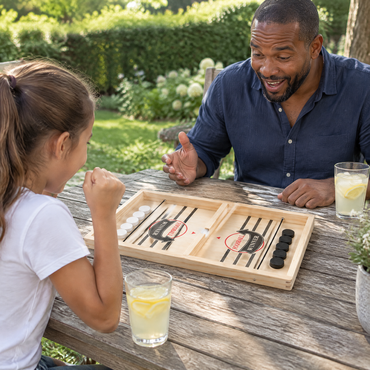 SwiftBoard Vater und Tochter spielen am Gartentisch